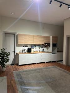 a large kitchen with white cabinets and a table at شقة فاخرة بغرفة سينما وحديقة in Qabāʼ +12 photos