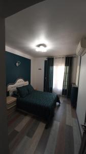 a bedroom with a green bed and a window at Hébergement chez Alice in Montauban