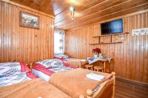 een kamer met twee bedden en een tv aan de muur bij Willa Klimek Biały Dunajec in Zakopane