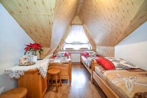 twee bedden in een kamer met een tafel en een raam bij Willa Klimek Biały Dunajec in Zakopane