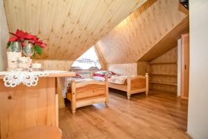 a attic room with a bed and a table at Willa Klimek Biały Dunajec in Zakopane