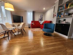 a living room with a red couch and a blue chair at Maison 3 chambres Inspiration in Amos