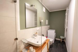 a bathroom with a sink and a mirror at ANER 3 Deluxe Apartment Pepe in Dresden +27 photos