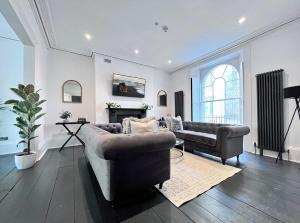 a living room with two couches and a fireplace at Exquisite Period House, Heart of Exeter, Parking in Exeter
