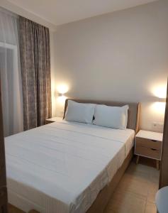 a bedroom with a large bed with white sheets and pillows at Navarino Luxe Suites in Perea