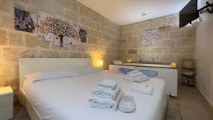 a bedroom with a white bed with towels on it at La Suite in Centro con vasca idromassaggio - Relax & Spa in Bari