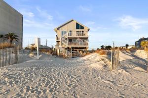 a house sitting on top of a sandy beach at Beachfront - 2 Bedrooms - Big Screen TV in Gulf Shores