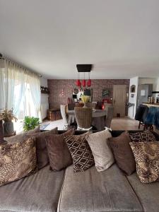 a living room with a couch with many pillows at Maison proche du Circuit des 24h in Ruaudin