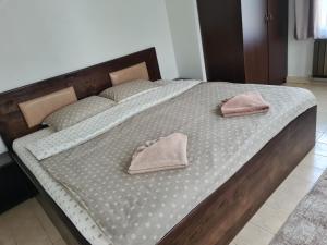 a large bed with two pink pillows on it at Мальовица - къща за гости in Dospey Makhla