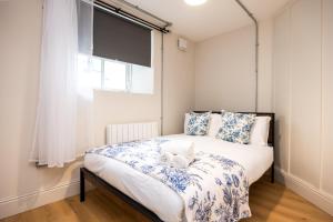 a bedroom with a bed with blue and white sheets and a window at Modern Studio APT - 20 Min Walk to Ha penny Bridge in Dublin