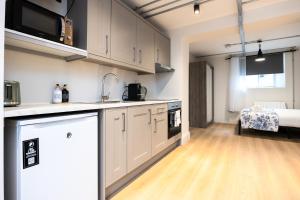 a kitchen with white cabinets and a bed in a room at Modern Studio APT - 20 Min Walk to Ha penny Bridge in Dublin