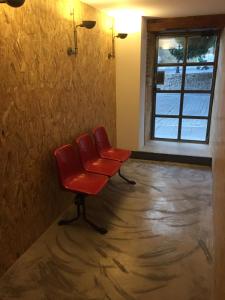 a red chair in a room with a window at Suites La Catedral in León