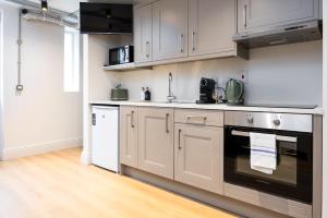 a kitchen with white cabinets and a black oven at Modern Studio APT - 20 Min Walk to Ha penny Bridge in Dublin +4 photos
