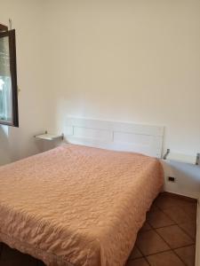 1 dormitorio con 1 cama con colcha de color naranja en Alloggio Turistico Miri, en Ciampino