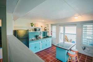 a kitchen with blue cabinets and a table and chairs at Ocean Front Villa 2 in Culebra