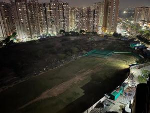 a large field in the middle of a city at night at Golden palace studio in Noida +4 photos