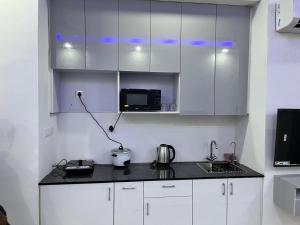 a kitchen with white cabinets and a counter top at Golden palace studio in Noida