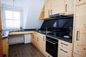 a kitchen with wooden cabinets and black appliances at Ferienhof Sonnengarten in Gunzenhausen
