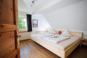 a bedroom with a bed with white sheets and a window at Ferienhof Sonnengarten in Gunzenhausen