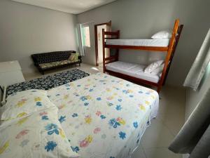 a bedroom with two beds and a bunk bed at Casa Rosa Pestana - min da Praia - PRADO BAHIA in Prado +21 photos