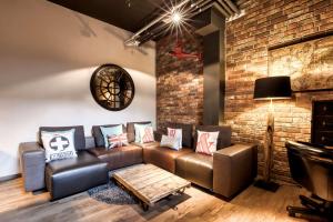 a living room with a couch and a brick wall at Pentahotel Brussels Airport in Diegem +30 photos