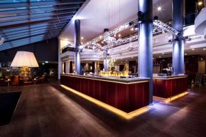 un bar in una grande sala con tavoli e sedie di Pentahotel Leipzig a Lipsia