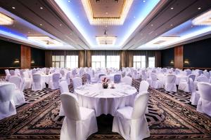 una sala per banchetti con tavoli bianchi e sedie bianche di Pentahotel Leipzig a Lipsia Altre 37 foto