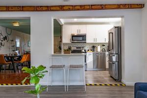 una cocina con armarios blancos y electrodomésticos de plata en Casa Fillmore - Hollywood Oasis, en Hollywood