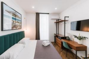a bedroom with a bed and a desk and a tv at Raggio di Sole in Maiori +66 photos