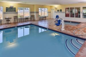 una piscina con mesas y sillas en una habitación de hotel en Holiday Inn Express & Suites Salt Lake City N - Bountiful, en Bountiful