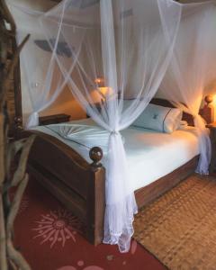 a bedroom with a canopy bed with white curtains at Hotel Isla Fuerte Ecohouse in Puerto Limón +145 photos