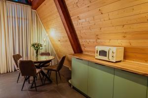 a kitchen with a table and a microwave on a counter at V Peaks Family A Frames in Dilijan in Dilijan