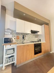 a kitchen with white cabinets and a stove top oven at Appartamento AL SOLE a Marina di Cecina by Zoom In Earth in Marina di Cecina