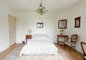 - une chambre avec un grand lit blanc et un lustre dans l'établissement L'Auberge 91530, à Le Val-Saint-Germain 37 autres photos