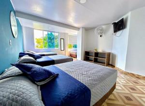 a large bedroom with two beds and a television at Hotel Zipa Villeta - Sede Campestre in Villeta