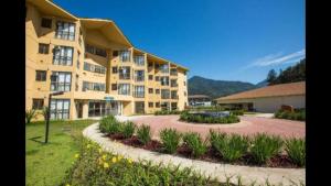 a large apartment building with a garden in front of it at Reserva do Sahy, Condado 2/305 in Mangaratiba