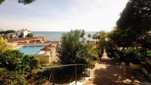 a house with a swimming pool next to the ocean at Mansión Alhamar Beachfront in Sitio de Calahonda