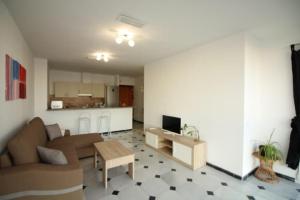 a living room with a couch and a kitchen at Mansión Alhamar Beachfront in Sitio de Calahonda