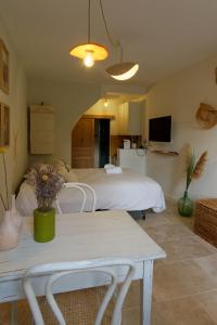 a bedroom with a bed and a table with flowers on it at 095 - Le Petit Camarguais - Studio - Calme - WIFI in Pérols