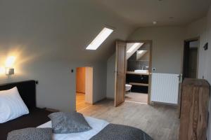 a bedroom with a bed and a bathroom at landhoeve in Hooithoek