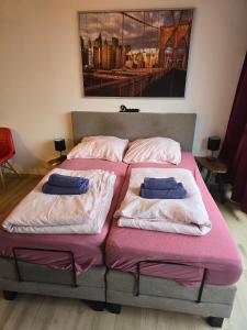 Dos camas en un dormitorio con un cuadro en la pared. en Cityapartments MH, en Mülheim an der Ruhr 4 fotos más