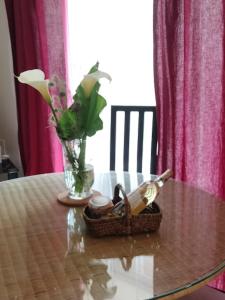 un tavolo con un vaso di fiori e un cesto di scarpe di Maison Pucet a Pey