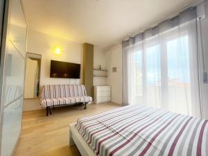a bedroom with a bed and a large window at Appartamento AL SOLE a Marina di Cecina by Zoom In Earth in Marina di Cecina