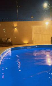 Una gran piscina azul por la noche con luces. en Salão de Festa com piscina, en Pelotas