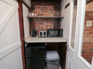 ein winziges Haus mit einer Mikrowelle und einem Mülleimer in der Unterkunft The Old Mill Cottage in Whitby