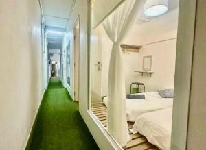 a room with a green floor and two beds at Jonker Vibe Inn in Malacca
