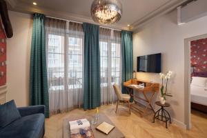 a living room with a couch and a bed and a desk at Le Robinet d'Or Paris Canal Saint Martin in Paris