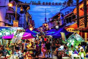 a crowd of people walking through a market at night at Jonker Vibe Inn in Malacca