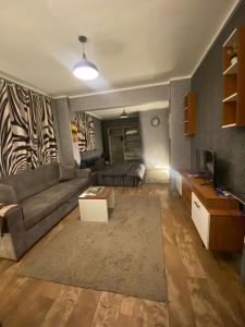 Una sala de estar con un sofá y un televisor. en جراند ماجيك استوديو, en El Cairo