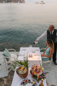 a man and woman sitting at a table near the water at Miramare Sea Resort & Spa in Ischia